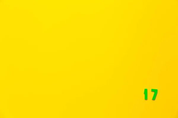 Зеленая Пластиковая Игрушка Номер Семнадцать Находится Правом Нижнем Углу Желтом — стоковое фото
