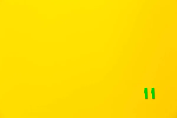 Numaralı Yeşil Plastik Oyuncak Sarı Arka Planda Sağ Alt Köşede — Stok fotoğraf