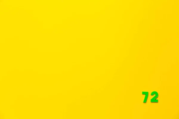 Zelená Plastová Hračka Číslo Dvaasedmdesát Umístěna Pravém Dolním Rohu Žlutém — Stock fotografie