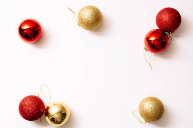 Beyaz arka planda izole edilmiş Noel ağacı oyuncakları. Yeni yıl sim topları kırmızı ve altın rengi. Moda tarzında yazılar yazan şenlikli bir pankart. Yakın plan..