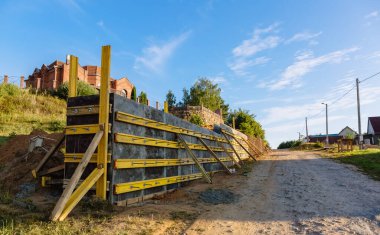 Bir istinat duvarı veya karşı kale inşaatı, formalite, takviye, beton dökme hazırlığı, inşaat alanı. Bölgenin gelişimi. Toprak kaymasına karşı önleyici tedbirler.