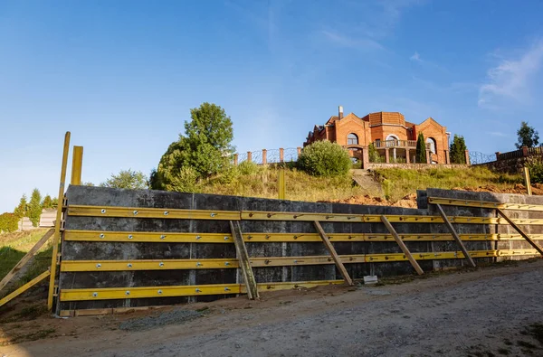 Bir istinat duvarı veya karşı kale inşaatı, formalite, takviye, beton dökme hazırlığı, inşaat alanı. Bölgenin gelişimi. Toprak kaymasına karşı önleyici tedbirler.