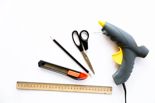 Cetvel, bıçak, makas, kalem ve yapıştırıcı beyaz arka planda izole edilmiş. Yaratıcı el sanatları yapmak için araçlar. Bu kırtasiye malzemesi yetişkinler tarafından ya da onların denetimi altında kullanılabilir. Üst görünüm düzeni