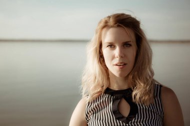 Gizli derisi, mutlu gözleri ve nazik bir gülümsemesi olan genç ve çekici bir kız gün batımında dışarıdayken mesafeye bakar. Bir insanın mutlu yüzü, iyi haber beklentisiyle iyi bir ruh hali içindedir..