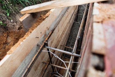 Beton dökmek ve bir bina ya da çit için sağlam bir temel oluşturmak için metal takviyeli kereste işi. İnşaat süreci.