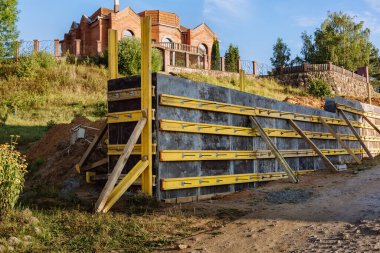 Bir istinat duvarı veya karşı kale inşaatı, formalite, takviye, beton dökme hazırlığı, inşaat alanı. Bölgenin gelişimi. Toprak kaymasına karşı önleyici tedbirler.