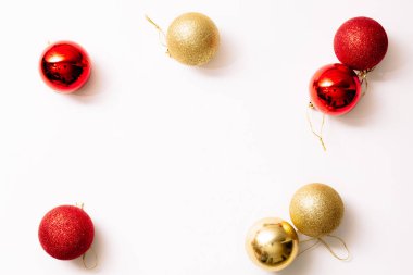 Beyaz arka planda izole edilmiş Noel ağacı oyuncakları. Yeni yıl sim topları kırmızı ve altın rengi. Moda tarzında yazılar yazan şenlikli bir pankart. Yakın plan..