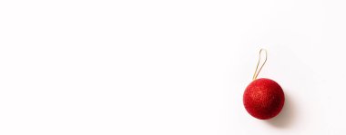 Beyaz arka planda izole edilmiş Noel ağacı oyuncağı. Yeni yıl parıltılı kırmızı renkli topu. Moda tarzında yazılar yazan şenlikli bir pankart. Yakın plan..