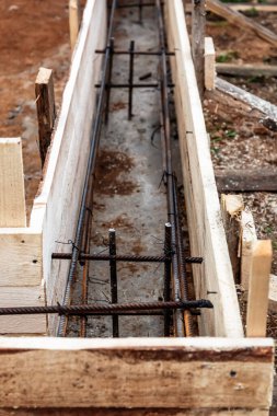Beton dökmek ve bir bina ya da çit için sağlam bir temel oluşturmak için metal takviyeli kereste işi. İnşaat süreci.