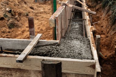 Beton dökmek ve bir bina ya da çit için sağlam bir temel oluşturmak için metal takviyeli kereste işi. İnşaat süreci.