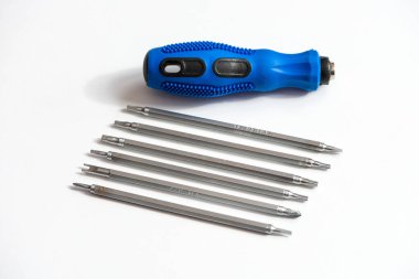 Mavi plastik kaplamalı metal tornavida ve beyaz arka planda çeşitli başlıklar..