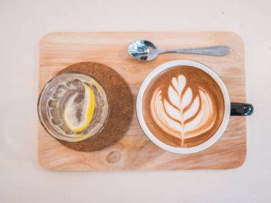 Sıcak kahve kalp mavi kadehte Ahşap dokusu üzerinde çizim..