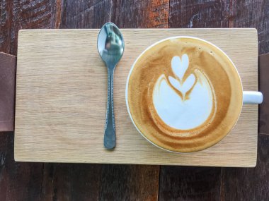 Sıcak kahve kalp mavi kadehte Ahşap dokusu üzerinde çizim..