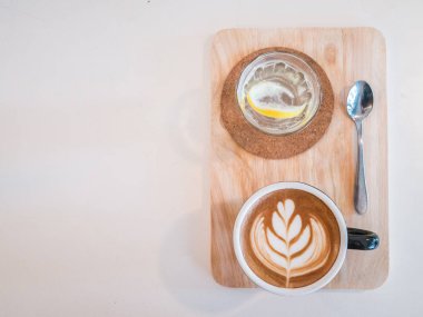 Sıcak kahve mavi bardakta kalbi ahşap dokusuna fotokopi alanı ile çiziyor..