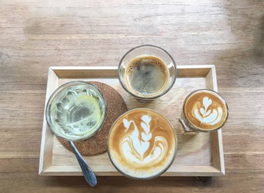 Sıcak kahve mavi bardakta kalbi ahşap dokusuna fotokopi alanı ile çiziyor..