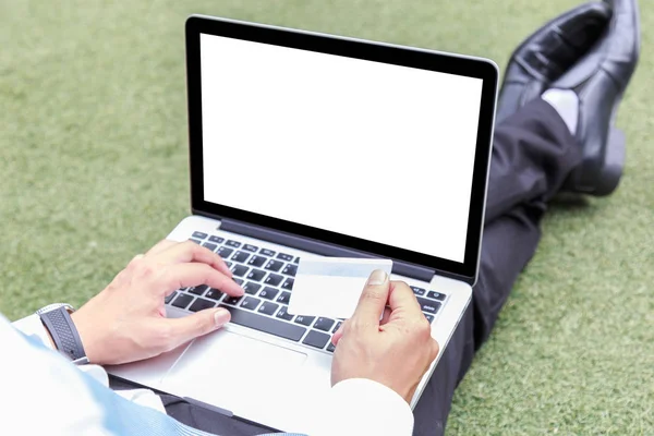 Businessman or student typing on keyboard laptop and holding credit card are shopping online. The blank screen with copy space for your text or advertising content. Selective focus and clipping path on picture.