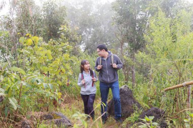 Asya baba ve kızı sırt çantası arkasında yürüyüş gitmek veya doğa dağ tırmanma.