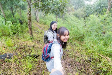 Asya kız anne ve kızı sırt çantası arkasında yürüyüş gitmek veya doğa dağ tırmanma.