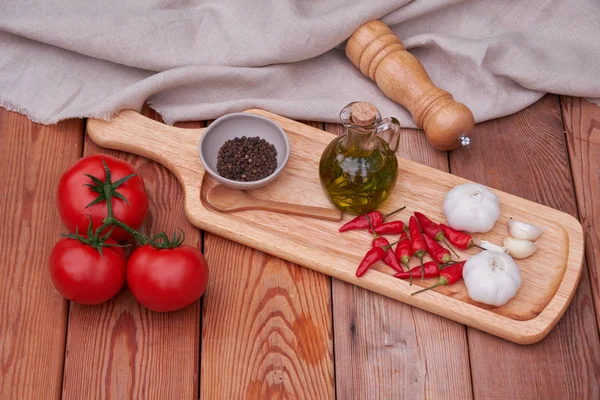 domates, biber, zeytin yağı bir ahşap plaka üzerinde. ülke stil