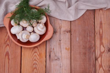 Champignon mantar, bir seramik tabak taze yeşillik. ülke stil