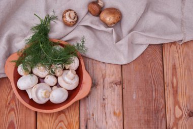 Champignon mantar, bir seramik tabak taze yeşillik. ülke stil