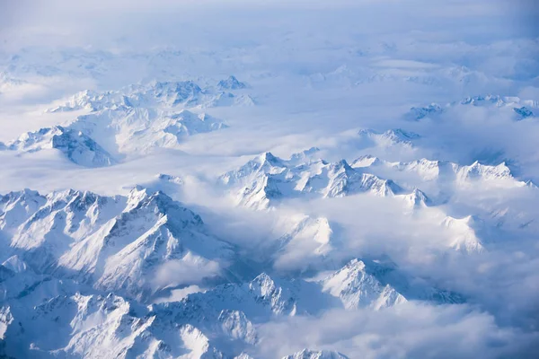 winter mountain in the clouds from aircraft