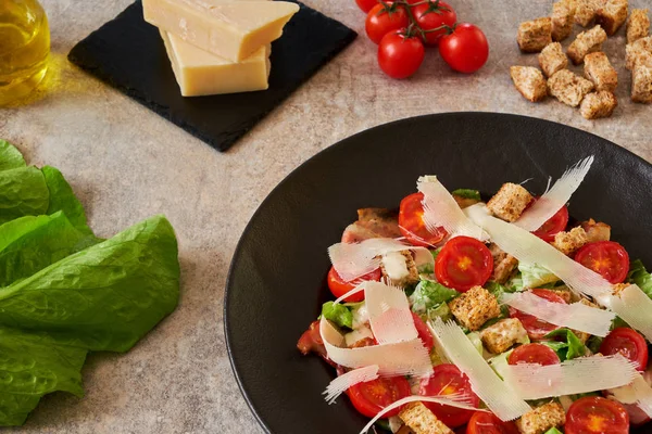 Sezar salatası malzemeler siyah bir tabakta