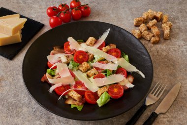 Sezar salatası malzemeler siyah bir tabakta