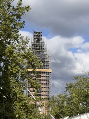 Bulutlu bir günde bina iskelesi ile kilise kulesi yenileniyor.