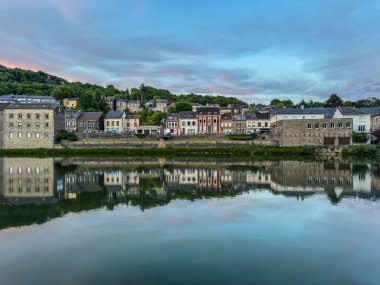 Gün batımında nehir kenarındaki evler su yüzeyine yansıyarak küçük bir Fransız kasabasında güzel bir manzara yaratıyor.