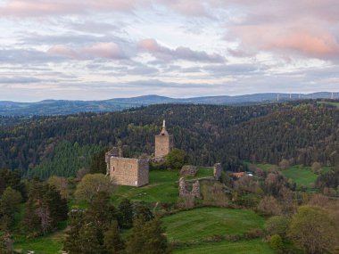 Luc Kalesi 'nin nefes kesen manzarası güzel bir günbatımında yeşil bir manzaranın ortasında duruyor.