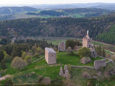 Luc Castel harabelerinin havadan görünüşü yenilenmiş kalesi, şapeli ve Bakire Meryem heykeli, Lozere manzarasına hükmediyor.