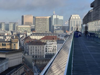 Belçika, Brüksel, 31 Aralık 2024; Brüksel iş bölgesi bulutlu bir günde terastan görülen modern binalar ve çatılarla gökyüzü