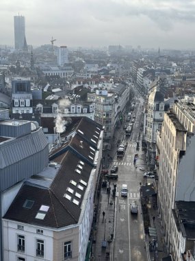 Belçika, Brüksel, 31 Aralık 2024; Bulutlu gökyüzü, Güney Kulesi, çatılar, Van Artevelde caddesi ve arabaların yer aldığı Brüksel kentsel manzarası