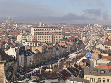 Belçika, Brüksel, 31 Aralık 2024; Brüksel, Belçika 'da belirgin bir dönme dolap ve kentin manzarasının yer aldığı canlı bir noel pazarının havadan görünüşü