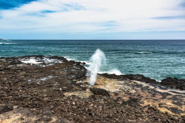 Water shoots along Spouting Horn coast, Kauai, Hawaii clipart