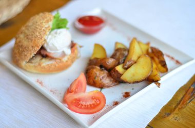 burger ve haşlanmış yumurta soslu dilimlenmiş patates kızartması
