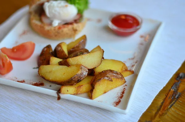 fried potatoes sliced with burger and poached egg with sauce