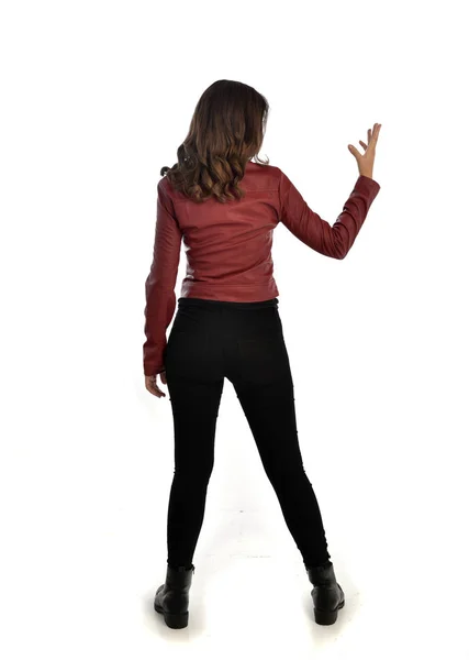 赤い革のジャケット 黒のジーンズとブーツを身に着けているブルネットの女の子の完全な長さの肖像画 立ちポーズ 白いスタジオ背景に分離 — ストック写真