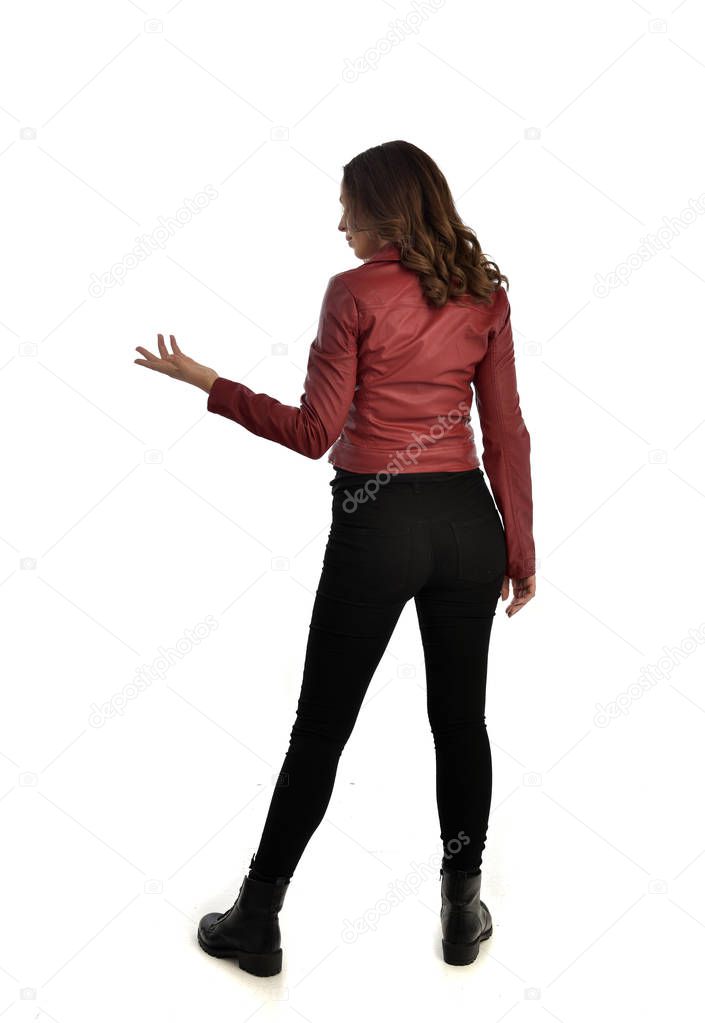 full length portrait of brunette girl wearing red leather jacket, black jeans and boots. standing pose, isolated on white studio background.