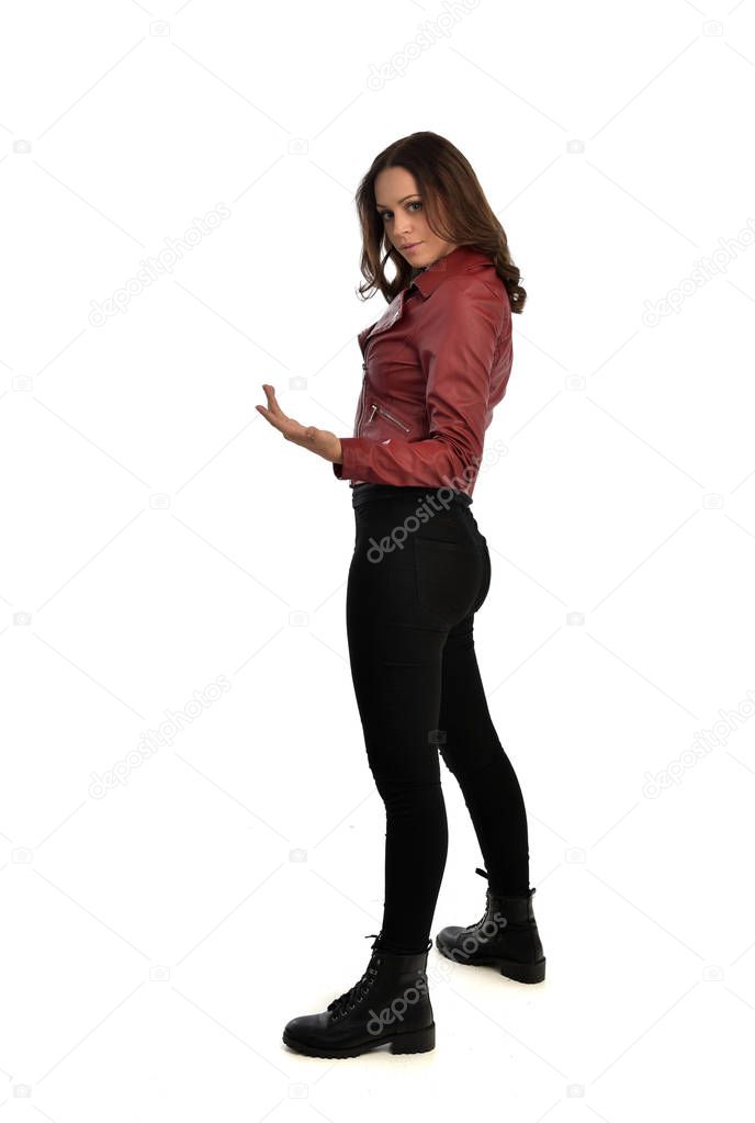 full length portrait of brunette girl wearing red leather jacket, black jeans and boots. standing pose, isolated on white studio background.