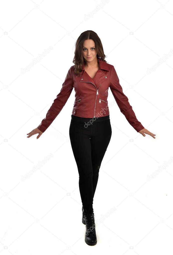 full length portrait of brunette girl wearing red leather jacket, black jeans and boots. standing pose, isolated on white studio background.