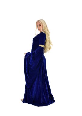 tam uzunlukta bir mavi fantezi Ortaçağ elbisesi giymiş güzel sarışın kadın portresi. ayakta poz fotoğraf makinesi beyaz stüdyo arka plan üzerinde uzak karşı karşıya.