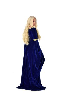 tam uzunlukta bir mavi fantezi Ortaçağ elbisesi giymiş güzel sarışın kadın portresi. ayakta poz fotoğraf makinesi beyaz stüdyo arka plan üzerinde uzak karşı karşıya.