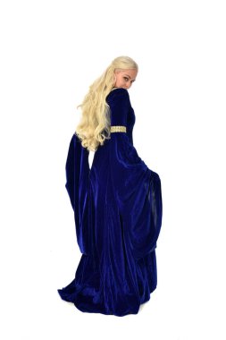 tam uzunlukta bir mavi fantezi Ortaçağ elbisesi giymiş güzel sarışın kadın portresi. ayakta poz fotoğraf makinesi beyaz stüdyo arka plan üzerinde uzak karşı karşıya.