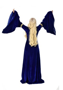 tam uzunlukta bir mavi fantezi Ortaçağ elbisesi giymiş güzel sarışın kadın portresi. Beyaz arka plan üzerinde ayakta poz.