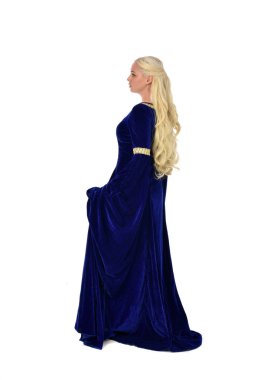 tam uzunlukta bir mavi fantezi Ortaçağ elbisesi giymiş güzel sarışın kadın portresi. Beyaz arka plan üzerinde ayakta poz.