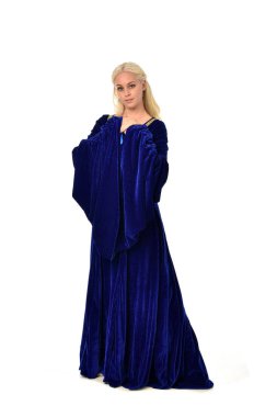 tam uzunlukta bir mavi fantezi Ortaçağ elbisesi giymiş güzel sarışın kadın portresi. Beyaz arka plan üzerinde ayakta poz.