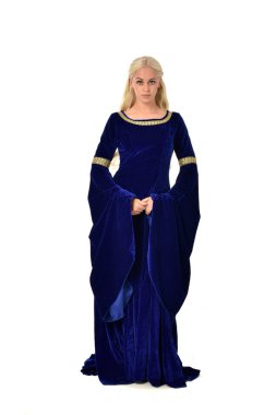 tam uzunlukta bir mavi fantezi Ortaçağ elbisesi giymiş güzel sarışın kadın portresi. Beyaz arka plan üzerinde ayakta poz.