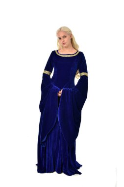 tam uzunlukta bir mavi fantezi Ortaçağ elbisesi giymiş güzel sarışın kadın portresi. Beyaz arka plan üzerinde ayakta poz.